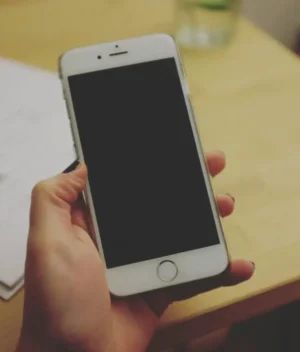 te pueden llevar a juicio por una deuda de telefono defensa monitorio mano agarrando móvil y sobre la mesa una carta con membrete de juzgado